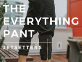 Close-up of black Jetsetter pants, labeled The Everything Pant, showcasing ankle cuffs and gold zippers indoors