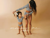 Mother and child hold hands in matching leopard print swimwear against a tan background with Mommy and Me Swims text