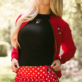 Close up of woman wearing the perfect Disneyland outfit—a black Minnie Mouse tank top, red Mickey Mouse jacket, and red polka dot Minnie Mouse skirt