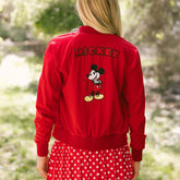 Back view of woman wearing lightweight Disney jacket—red bomber with Mickey Mouse embroidery—the perfect women's Disney jacket.