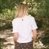 Back view of woman wearing a women's Disney shirt—embroidered Mickey Mouse detail on the shirt and subtle, women's Minnie Mouse shorts.