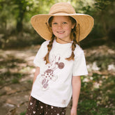 Young girl wearing a wide-brimmed hat and a kid's Minnie t-shirt and matching kid's Minnie shorts.