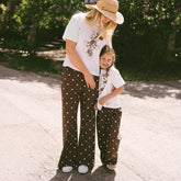 Mom and daughter wearing matching Disneyland outfits—kid's pants for Disneyland in brown Minnie Mouse print.