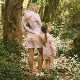 Mom and daughter standing in the forest wearing the perfect matching Disney outfits for the family.