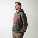 Man wearing a gray hoodie with red text on a plain background