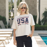 Woman wearing a USA T-shirt—the perfect 4th of July shirt for women in white with screen printed USA 1776 logo.