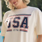 Close up of USA 1776 t-shirt on a woman with blurred background.