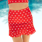 Woman standing in a pool wearing a red and white star swim skirt—the perfect 4th of July bathing suit.