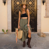 Front view of model wearing sporty black bikini top in terry towel fabric with a beachy olive maxi skirt