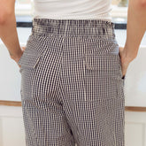 Close up back view of navy gingham pants with back pockets on a blurred background