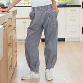 Woman wearing navy gingham balloon pants in kitchen setting.