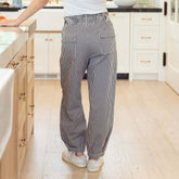 Back view of woman wearing flattering balloon pants in navy blue gingham print in a kitchen setting.