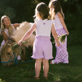 Children playing with a small pony in the gross and wearing cute Disney outfits for kids in purple