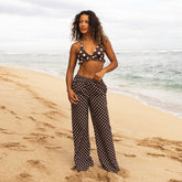 Woman in polka dot outfit standing on a beach