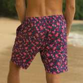 Person wearing a floral swim shorts on a beach