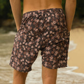 Person wearing floral shorts on a beach