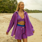 Women wearing a cute oversized button down as a beach cover-up with a matching swimsuit and boxer shorts on the beach