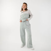Front view of model wearing matching sweat set with wide leg sweatpants and half zip pullover