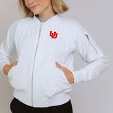 Showing the white full zip bomber jacket zipped up with a close up on the Utah logo in red