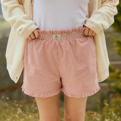 Close up view of red seersucker womens boxer shorts with ruffle details.