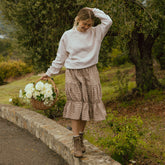 Model wearing cute midi skirt in brown gingham print. Relaxed fit, three tiered skirt that hits below the knee.