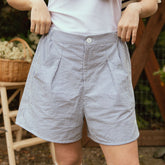 Close up of blue seersucker shorts for women with pleating. Wide, relaxed fit.