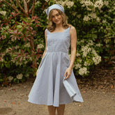 Model wearing beautiful blue seersucker dress with matching bandana. The dress is a flowy tank top dress with pleated skirt.