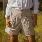Close of up brown striped women's shorts that are wide fit and relaxed with pleats and pockets.