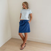Front view of the City Skirt in blue with blue polka dots showcasing its knee-length fit on a model indoors