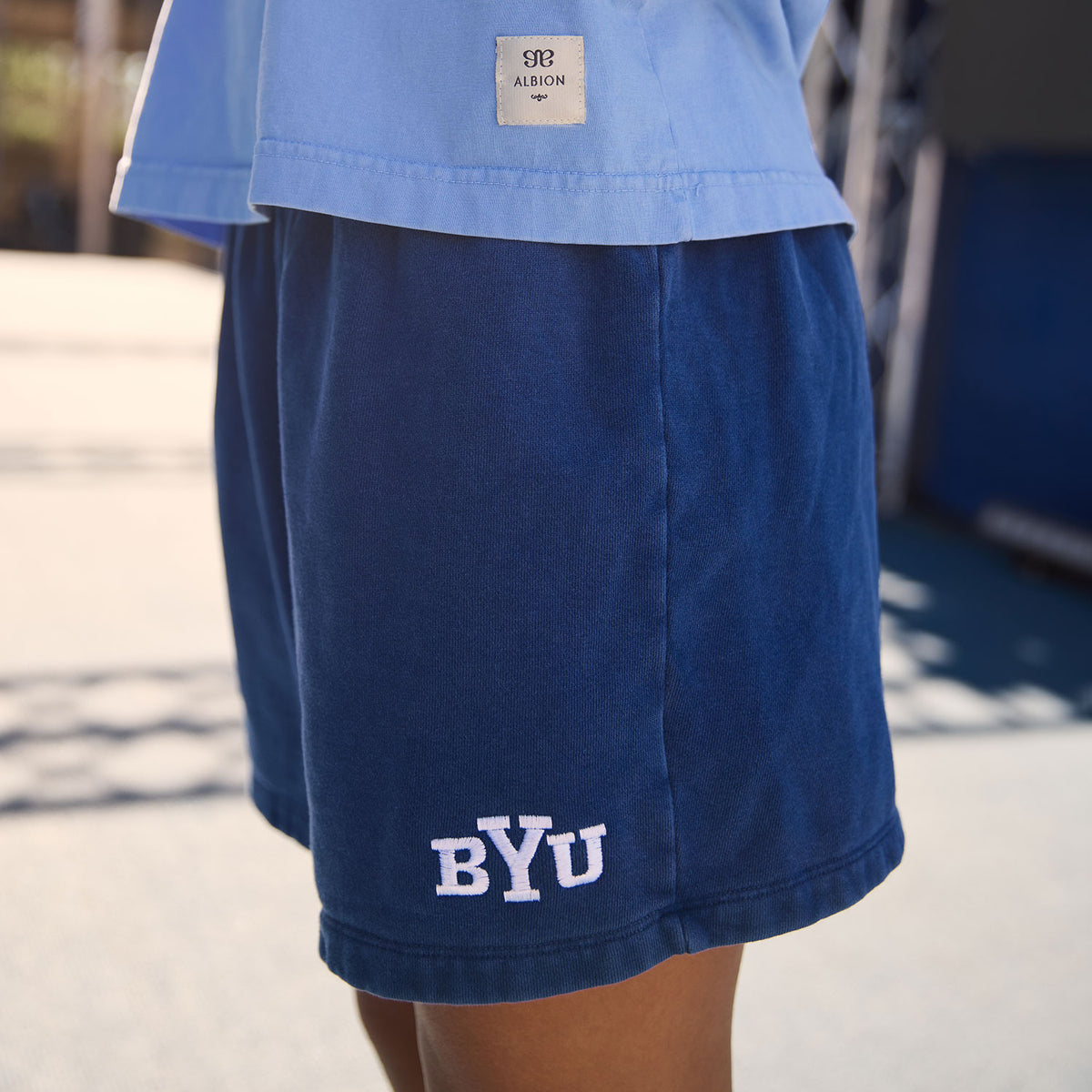 Close-up of navy BYU Go To Shorts showcasing embroidered BYU lettering on the leg with a model outdoors