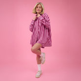 Woman wearing a cute matching set in pink stripes on a pink background