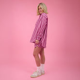 Person wearing a pink striped outfit on a pink background
