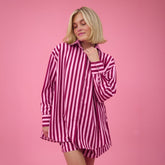Woman wearing a cute oversized button down in pink stripes with matching womens boxer shorts