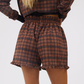 Rear close-up of Disney Mickey Lake plaid shorts showcasing elastic waistband and ruffled hems with a light background