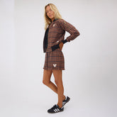 Three-quarter view of Disney Mickey Lake Shorts in brown plaid showcasing a Mickey emblem on a model