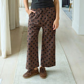 Woman wearing brown polka dot women's pants indoors