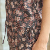 Close up of brown floral blouse with visible Albion logo on a blurred background