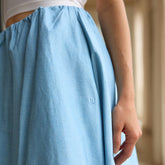 Close-up of a light blue skirt with an Albion brand logo, blurred background