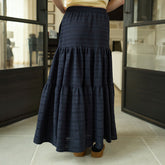 Woman wearing a black tiered skirt in an indoor setting
