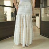 Woman wearing a long white skirt in a modern indoor setting