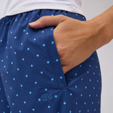 Close-up of blue and blue polka-dot Slip On Trouser showcasing the side pocket with a hand against a light background