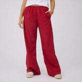 Front view of red polka dot slip-on trousers showcasing wide-leg fit with a light gray background