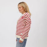 Side view of Utah Cardigan, Red Stripe showcasing red-and-cream horizontal stripes and chest logo on a model against light gray