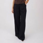 Women's wide-leg pants in black worn by a woman on a white background