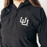 Close-up of a black quarter zip hoodie with the University of Utah logo in white.