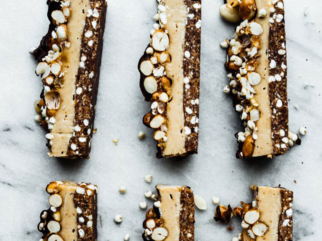 Overhead view of peanut butter pie bars with nut and oat topping on a marble surface