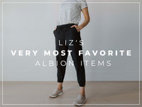 Model wearing a striped shirt, black jogger pants, and sneakers with headline Liz’s Very Most Favorite Albion Items