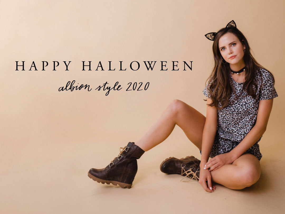 Woman in a leopard-print outfit and cat ears sits in boots for a Halloween fashion look, with “Happy Halloween” text