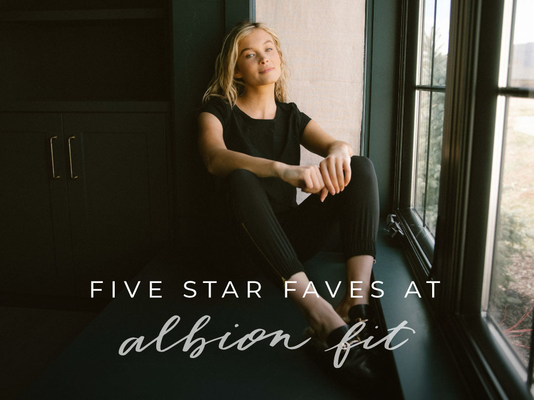 Woman in a black outfit sitting beside a window with text Five Star Faves at Albion Fit