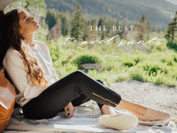 Woman relaxing in black Jetsetters travel pants outdoors with mountains behind her